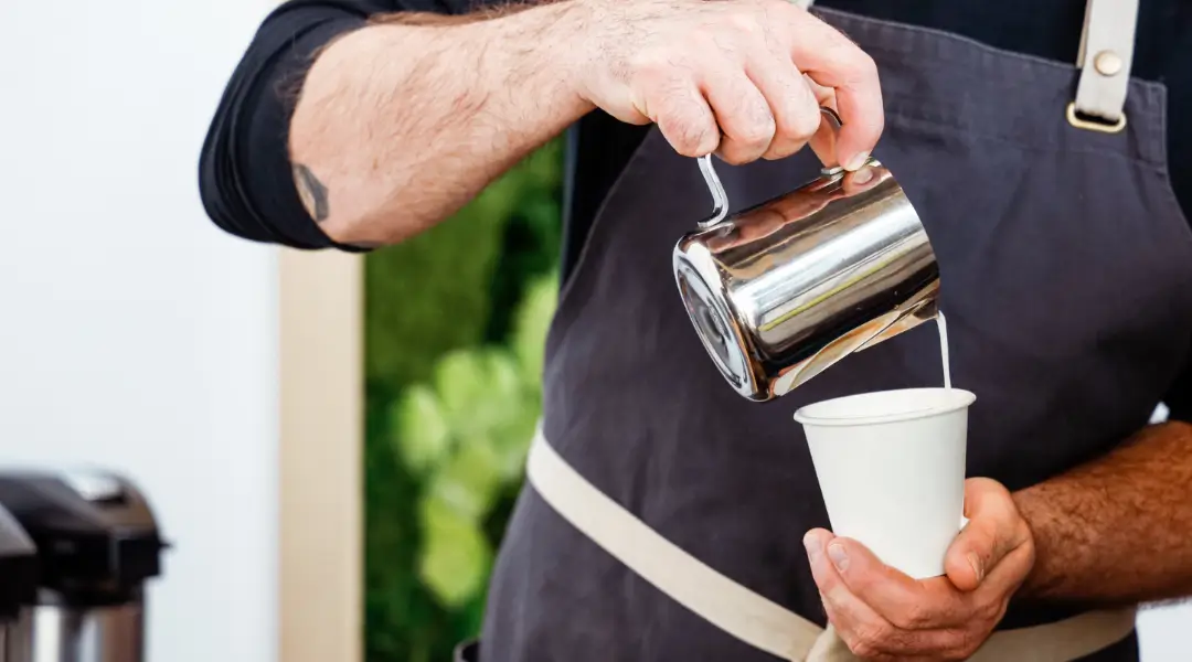 Coffee Break at Work - Relax and Recharge Barista pouring milk into a coffee cup during a coffee break at the office