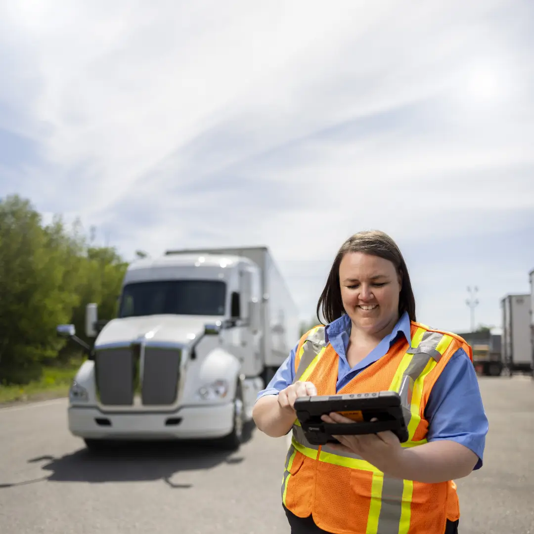 isaac-platform-fleet-operator-weigh-station Fleet operator using the ISAAC platform tablet at a weigh station in front of a semi-truck.