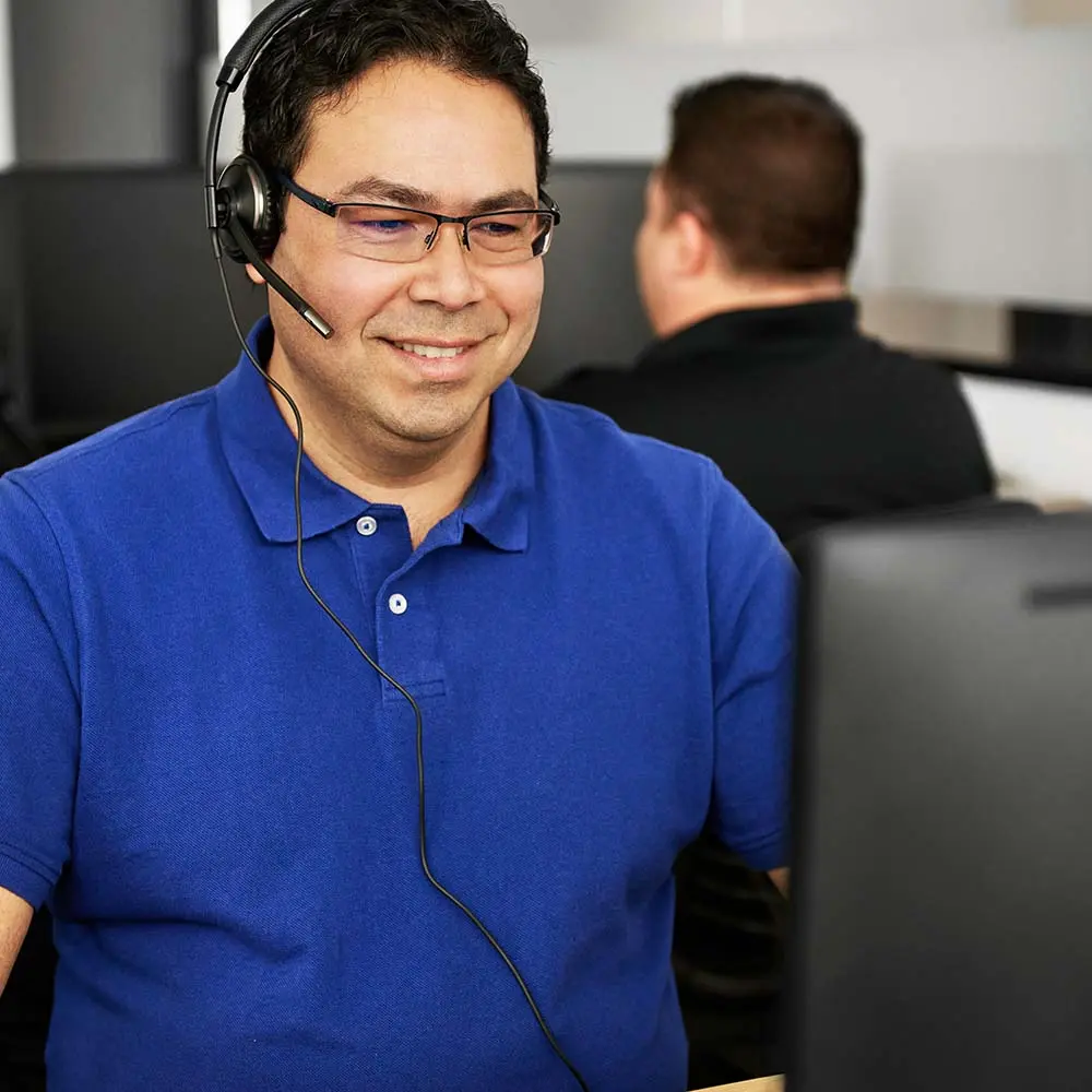 Remote support team member assisting drivers via ISAAC platform ISAAC support representative wearing headset providing remote assistance